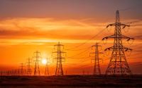 Pylons and electrical supply lines with a flaming sunset background
